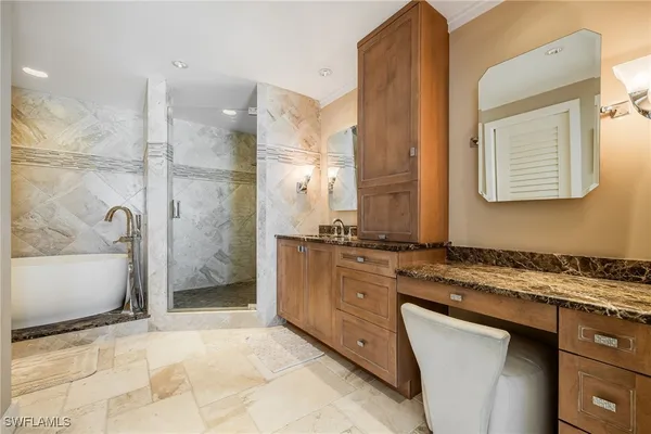a bathroom with a granite countertop sink a mirror and a bathtub