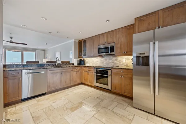 a kitchen with granite countertop a refrigerator sink and stove