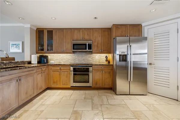 a kitchen with stainless steel appliances granite countertop a refrigerator and a stove top oven