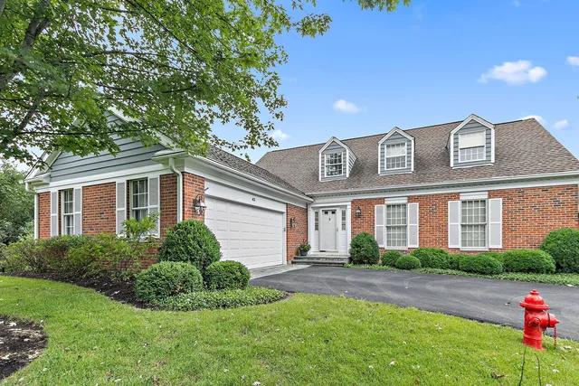 a front view of a house with a yard and potted plants