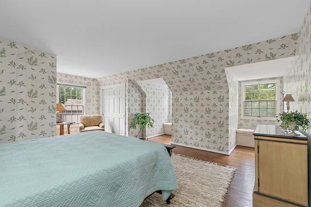 a bedroom with furniture and a large window