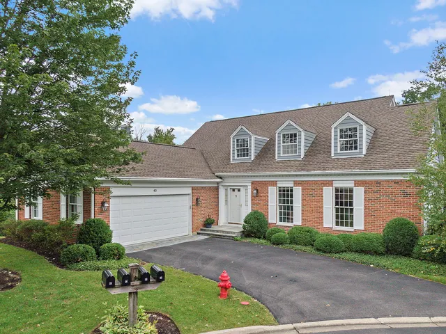 a aerial view of a house with yard and trees in the background