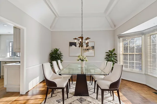 a dining room with furniture potted plants and wooden floor