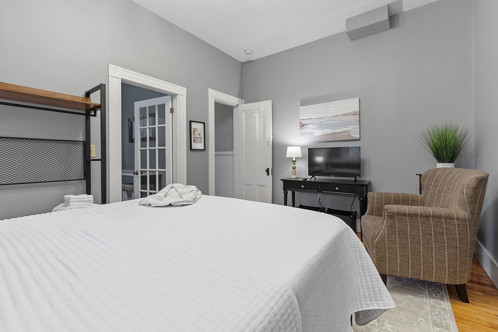 113 Main Street, Unit 3 Pepperell, MA 01463 - Photo 4 of 10 a large bedroom with a bed and a television