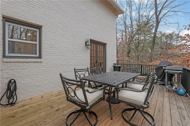 a view of a patio with table and chairs with wooden floor and fence