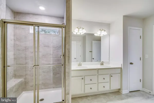 a bathroom with a double vanity sink mirror and shower