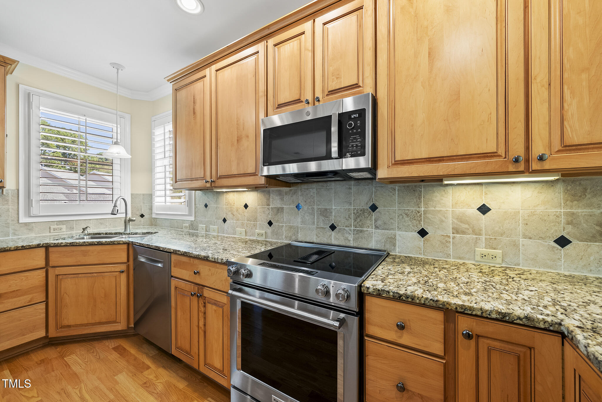 3700 Baron Cooper Pass, Unit 302 Raleigh, NC 27612 - Photo 29 of 67 a kitchen with stainless steel appliances granite countertop a stove a sink and a microwave