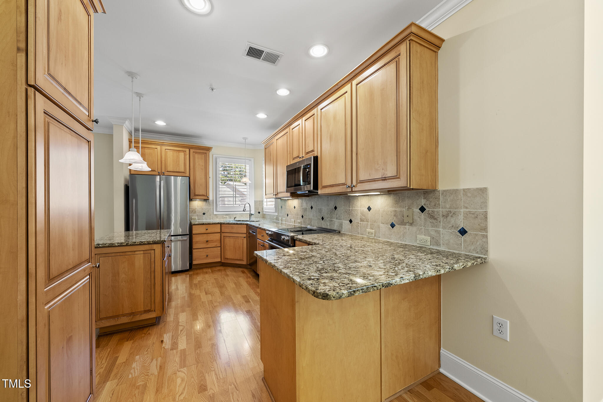 3700 Baron Cooper Pass, Unit 302 Raleigh, NC 27612 - Photo 31 of 67 a kitchen with stainless steel appliances granite countertop a sink refrigerator and microwave