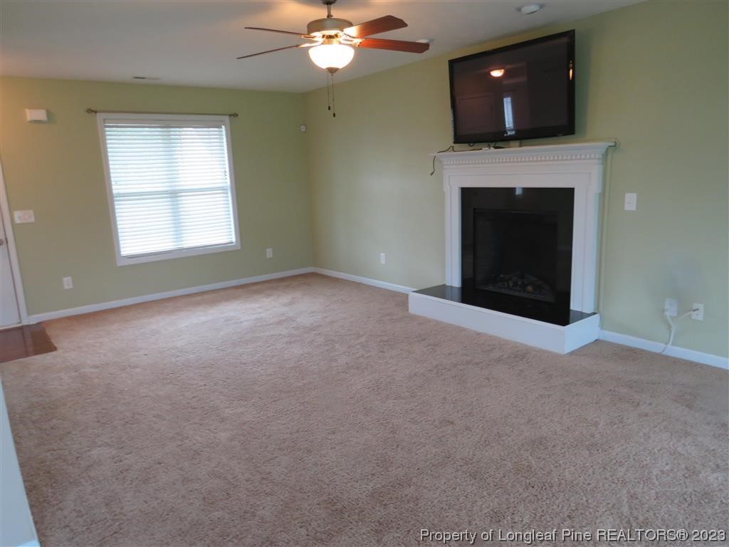 44 Archer Drive Bunnlevel, NC 28323 - Photo 2 of 10 an empty room with a fireplace and fan