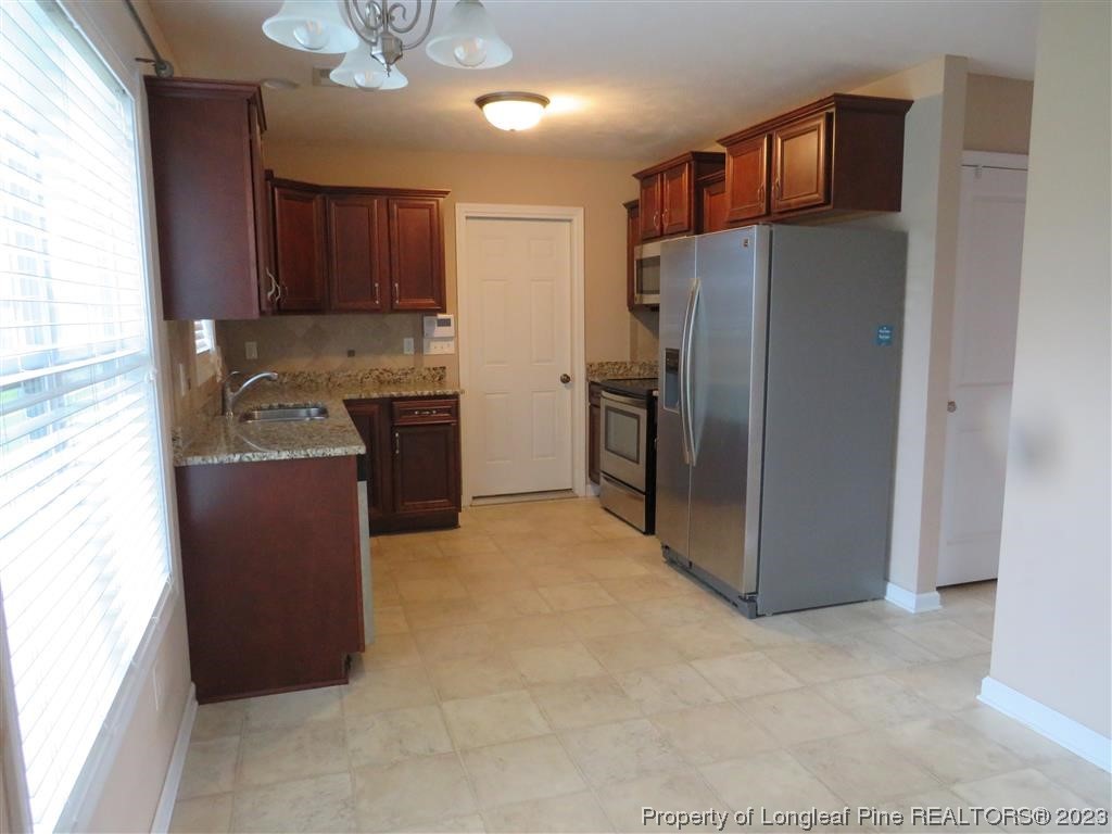 44 Archer Drive Bunnlevel, NC 28323 - Photo 4 of 10 a kitchen with stainless steel appliances granite countertop a refrigerator a stove and a sink