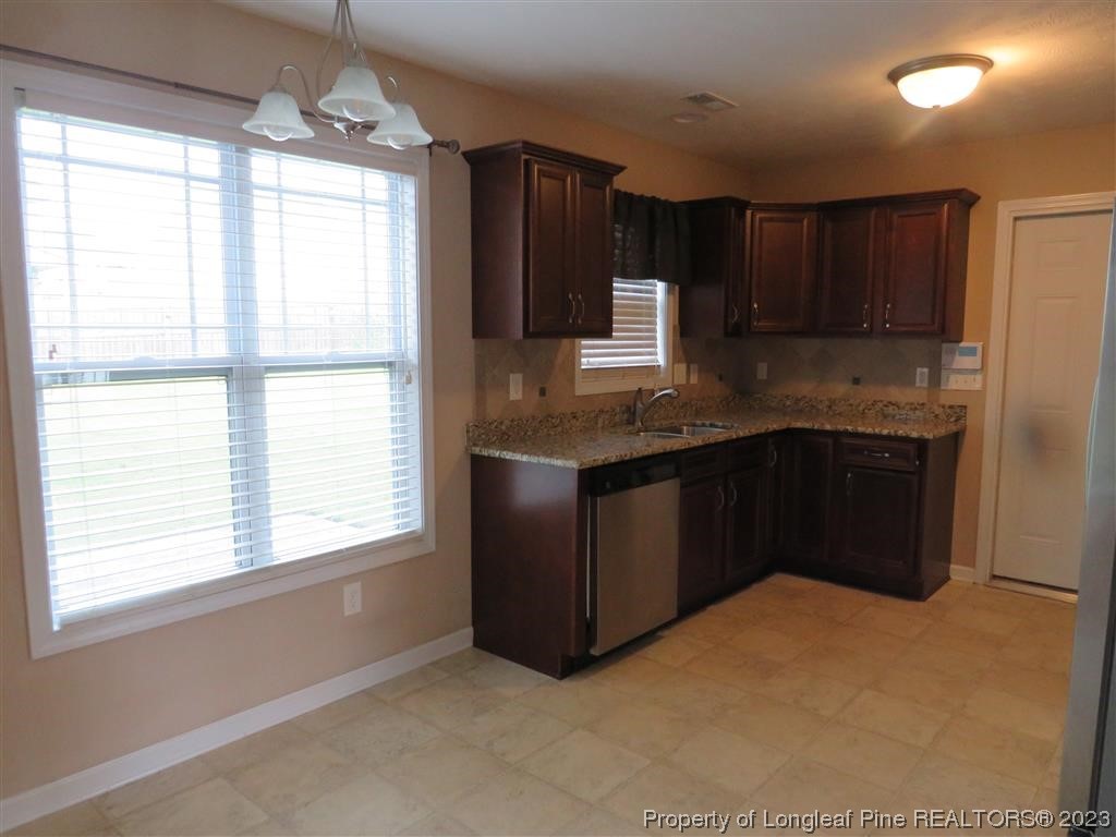 44 Archer Drive Bunnlevel, NC 28323 - Photo 5 of 10 a kitchen with stainless steel appliances granite countertop a stove a sink and a microwave