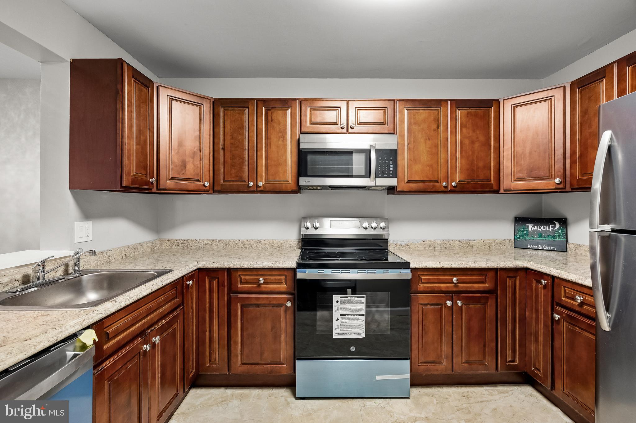 25 South Church Road, Unit 129 Maple Shade, NJ 08052 - Photo 9 of 24 a kitchen with stainless steel appliances granite countertop a stove a sink dishwasher and a microwave