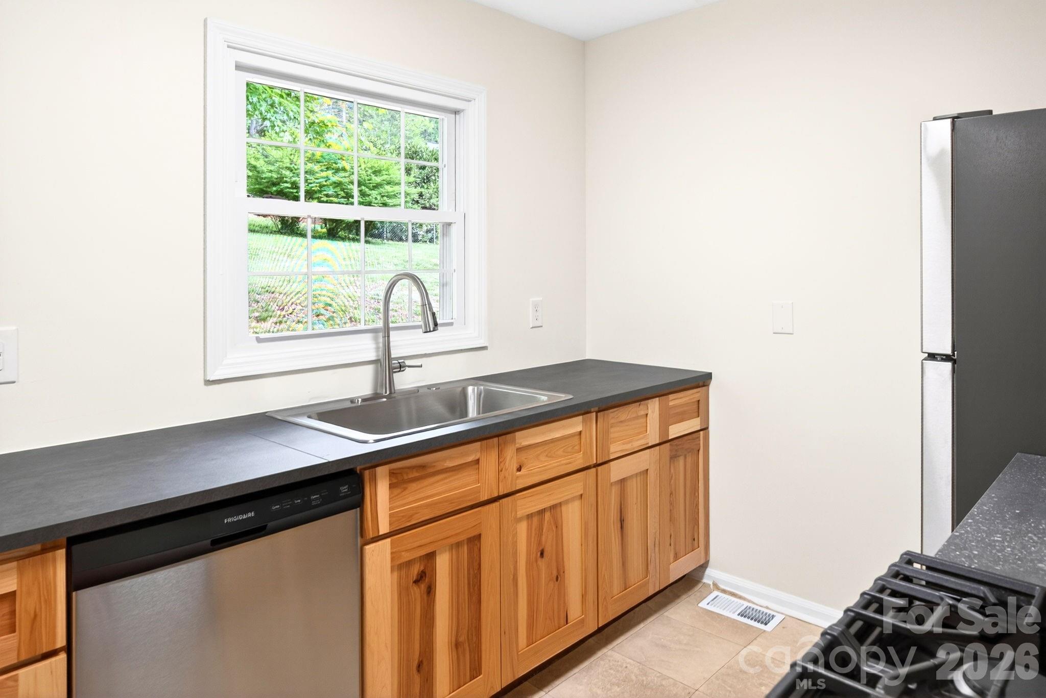 34 Wolfe Cove Road Asheville, NC 28804 - Photo 25 of 42 a kitchen with stainless steel appliances a sink stove and a window