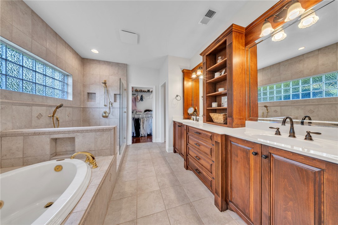 102 Country Walk Lane Clemson, SC 29631 - Photo 18 of 39 Custom cabinetry and ample counter space define this primary bathroom, featuring a deep soaking tub.