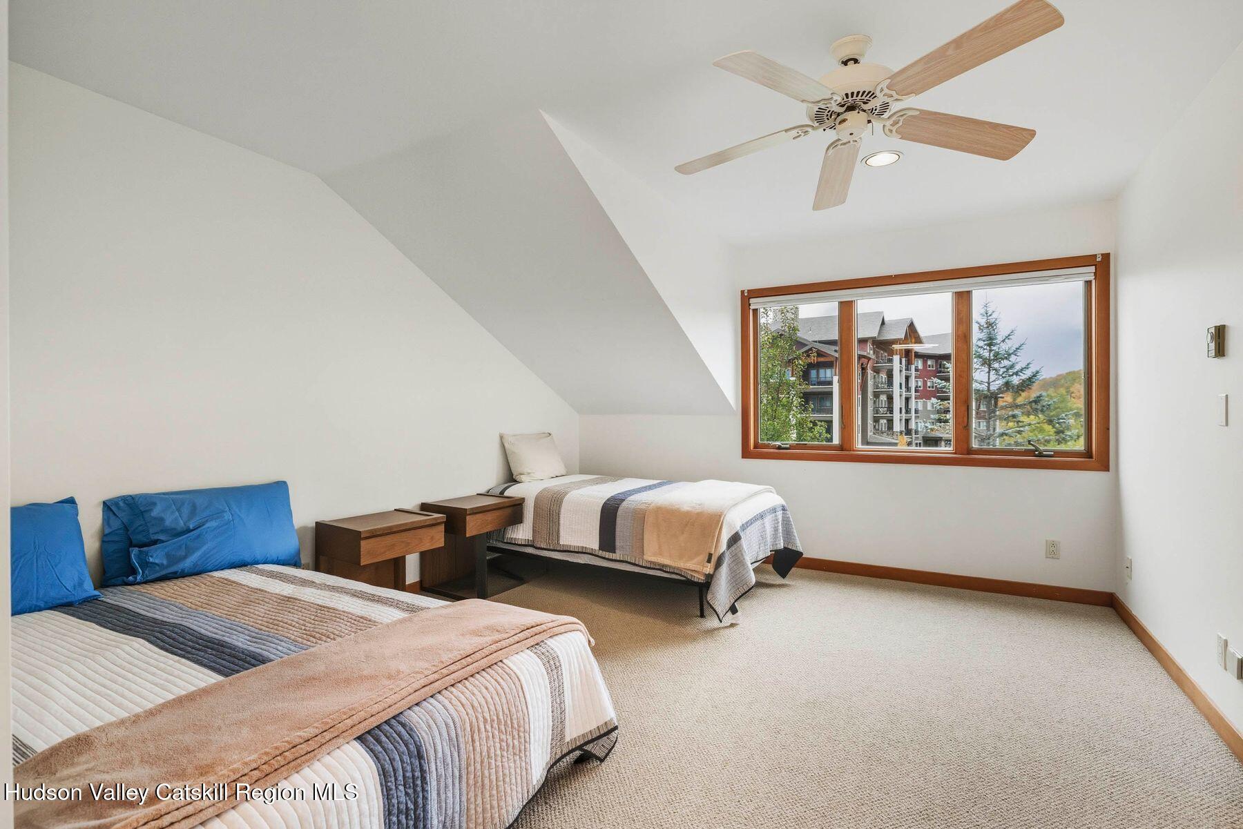 3 The Enclave Windham, NY 12496 - Photo 13 of 59 a bedroom with two beds and a chandelier