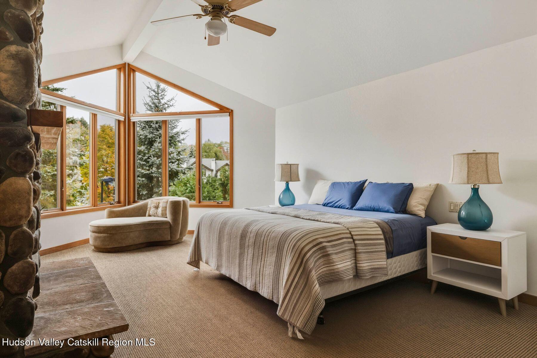 3 The Enclave Windham, NY 12496 - Photo 25 of 59 a bedroom with a bed couch and a large window