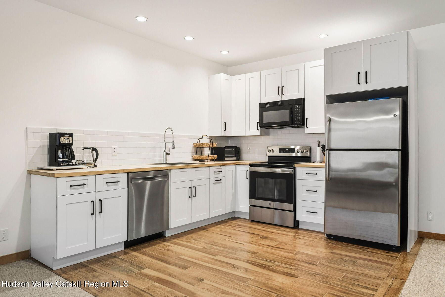 3 The Enclave Windham, NY 12496 - Photo 8 of 59 a kitchen with granite countertop a refrigerator stove and sink