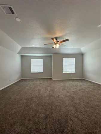 en empty room with windows and chandelier fan