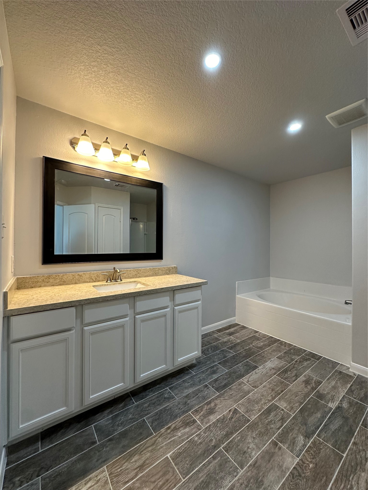 5819 Golden Cove Road Cove, TX 77523 - Photo 10 of 19 a bathroom with a tub sink and mirror