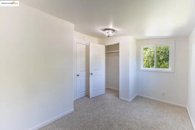 an empty room with windows and closet