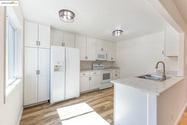 a kitchen with granite countertop a sink cabinets and stainless steel appliances