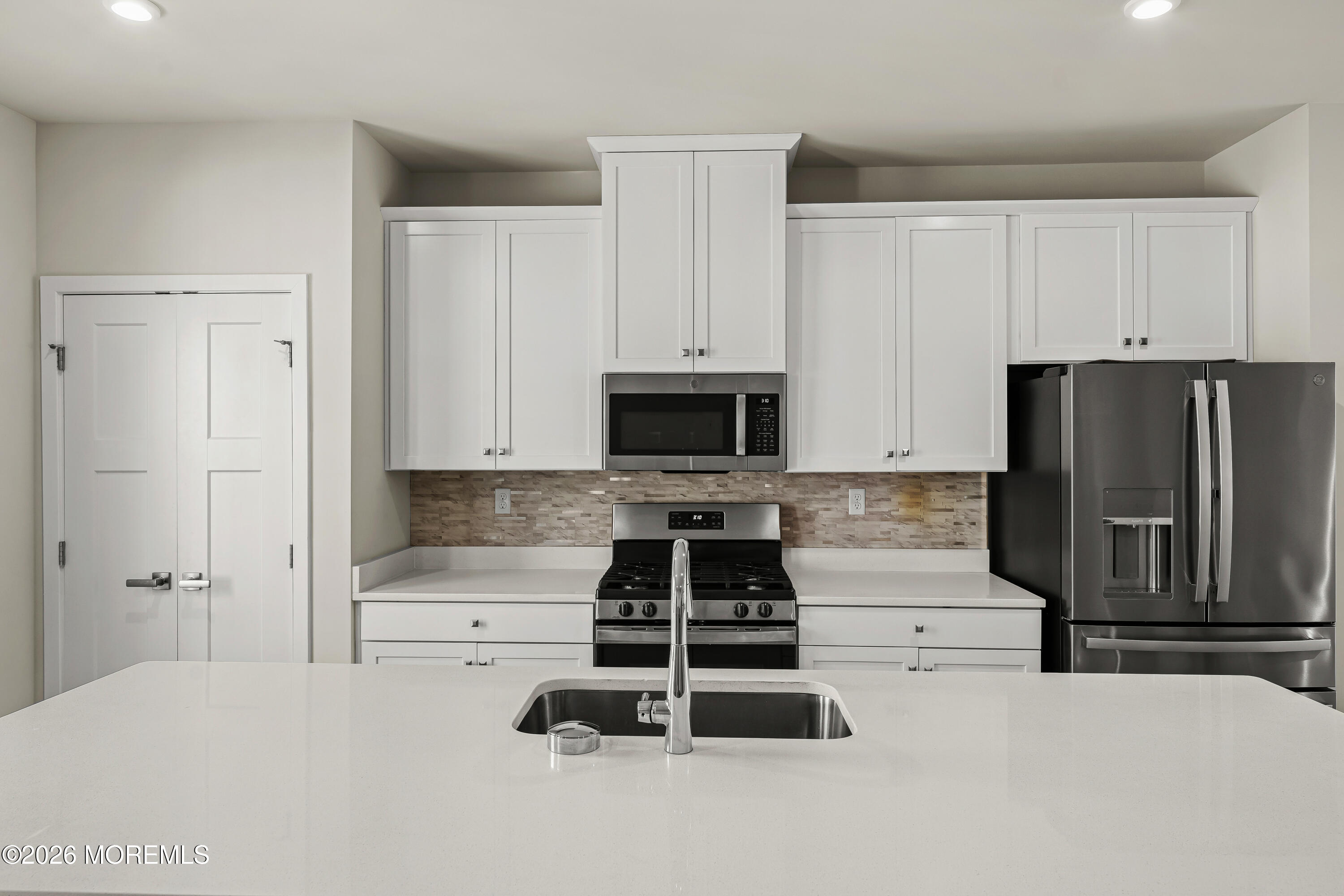 1306 English Lane, Unit 1306 Parlin, NJ 08859 - Photo 14 of 41 a kitchen with a refrigerator a stove and white cabinets