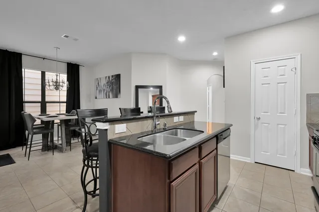 a kitchen that has a sink a table and chairs in it