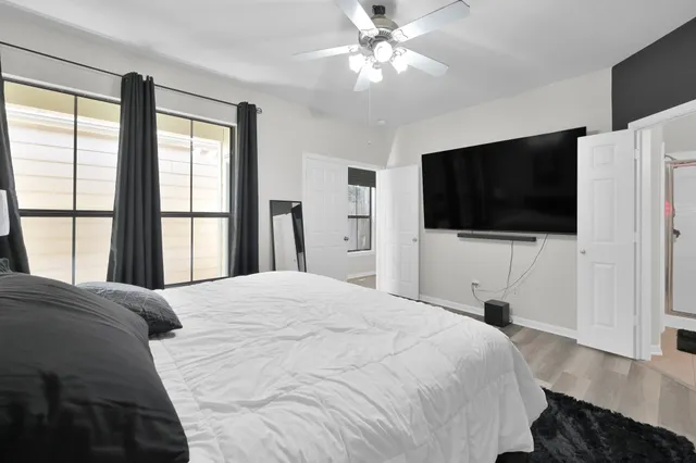 a bedroom with a bed tv and a window