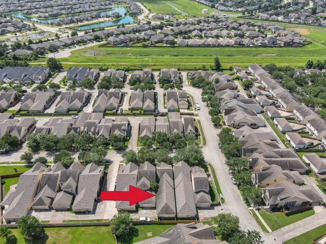 an aerial view of residential houses with outdoor space and lake view