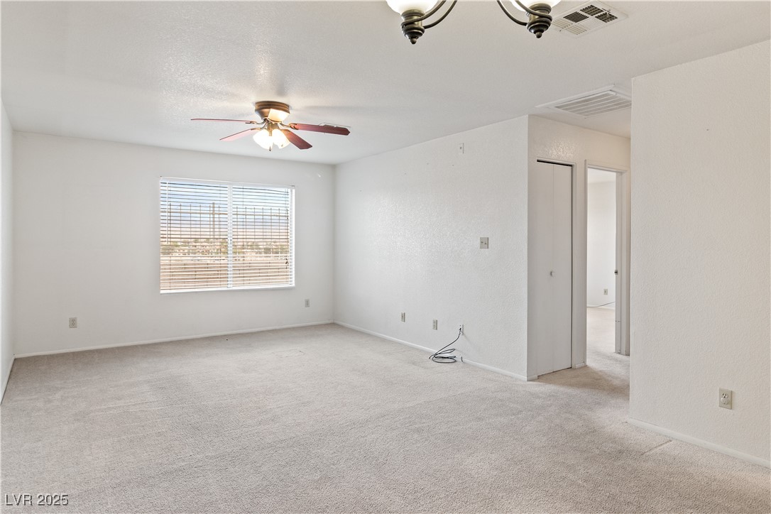 2036 Mesquite Lane, Unit 103 Laughlin, NV 89029 - Photo 12 of 67 Spare room featuring visible vents, baseboards, light colored carpet, and ceiling fan