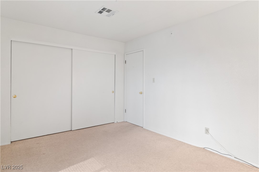 2036 Mesquite Lane, Unit 103 Laughlin, NV 89029 - Photo 27 of 67 Unfurnished bedroom with a closet, visible vents, and carpet