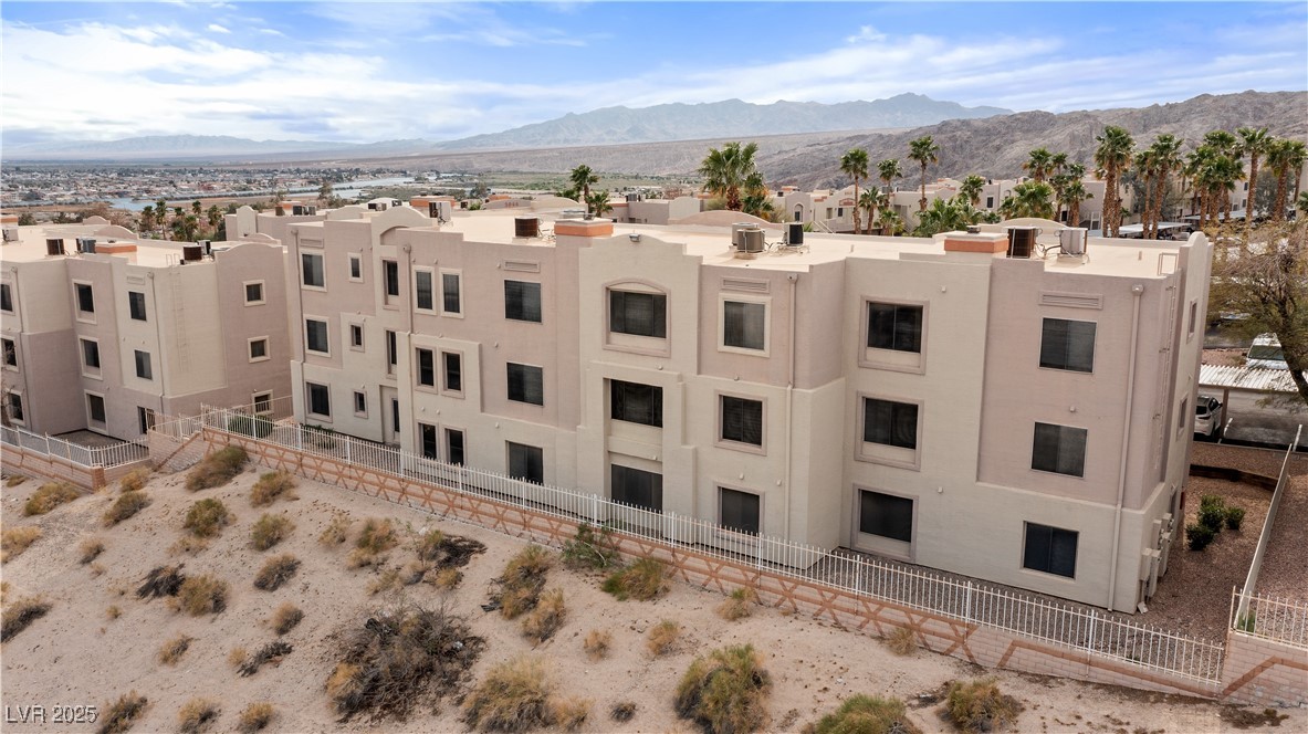 2036 Mesquite Lane, Unit 103 Laughlin, NV 89029 - Photo 43 of 67 View of building exterior featuring a residential view, fence, and a mountain view
