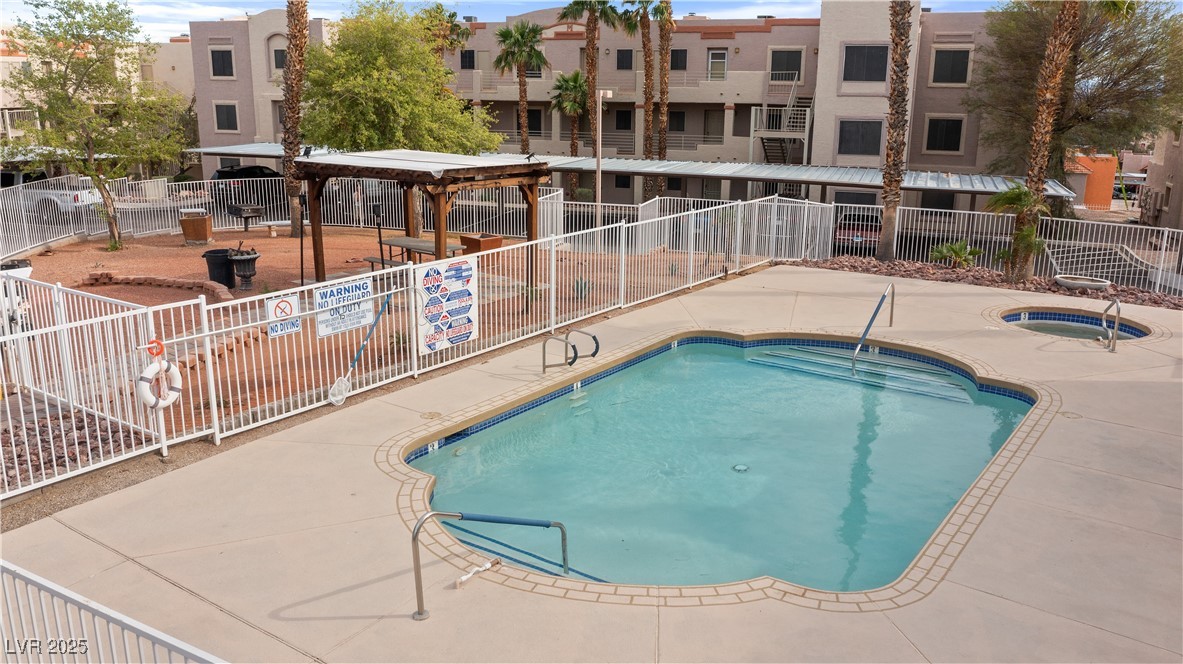 2036 Mesquite Lane, Unit 103 Laughlin, NV 89029 - Photo 49 of 67 Pool with a hot tub, fence, a patio, and a residential view