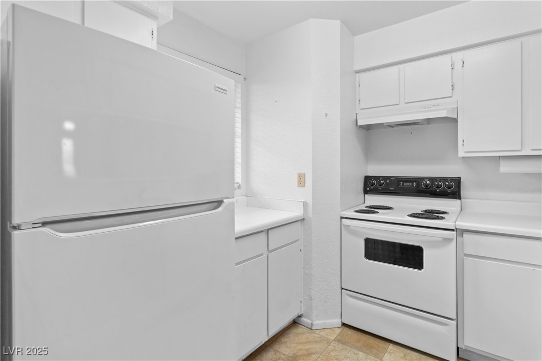 2036 Mesquite Lane, Unit 103 Laughlin, NV 89029 - Photo 6 of 67 Kitchen featuring white cabinetry, light countertops, under cabinet range hood, and white appliances