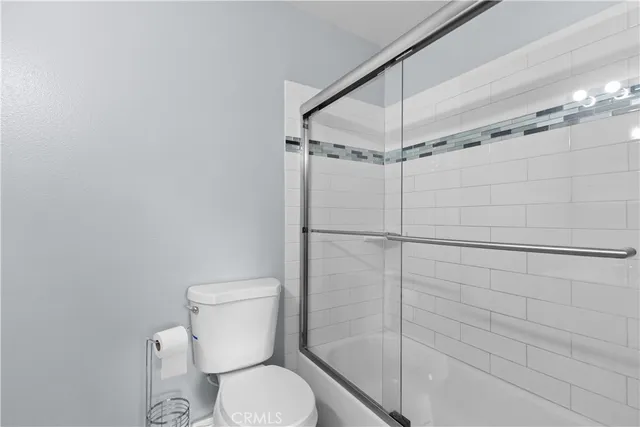 a white toilet sitting next to a shower