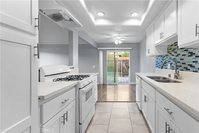 a kitchen with granite countertop a sink stove and cabinets