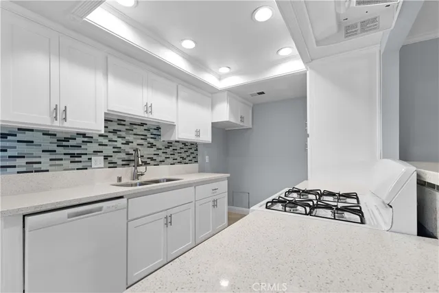 a kitchen with white cabinets and appliances