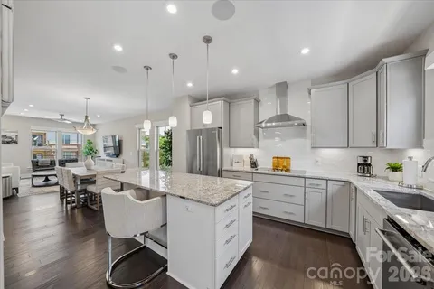 a kitchen with granite countertop kitchen island stainless steel appliances a refrigerator and a center island