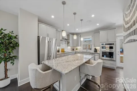a kitchen with stainless steel appliances granite countertop a sink stove and cabinets
