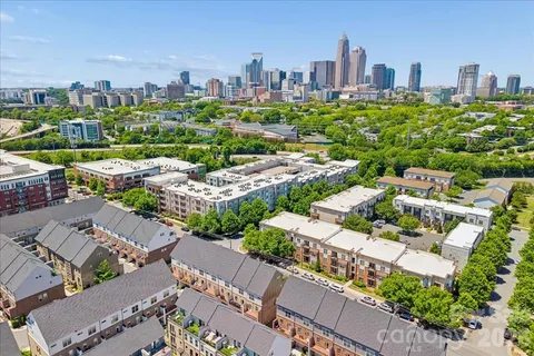 an aerial view of residential houses with outdoor space and trees