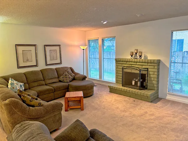 a living room with furniture a flat screen tv and a fireplace