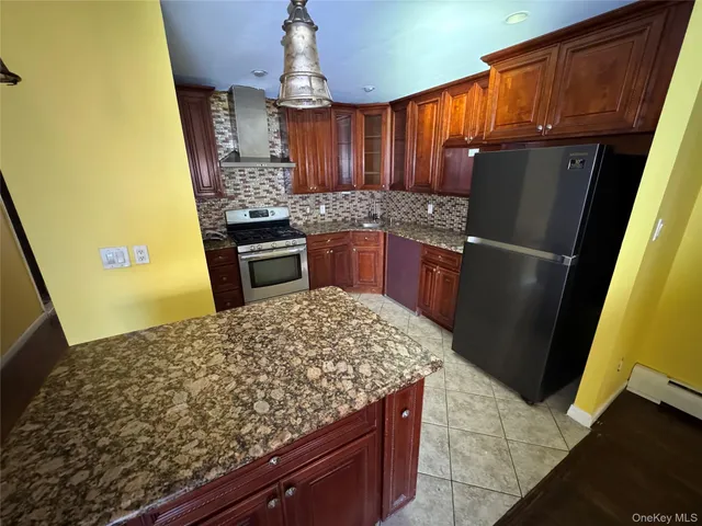 a kitchen with stainless steel appliances granite countertop a refrigerator and a stove