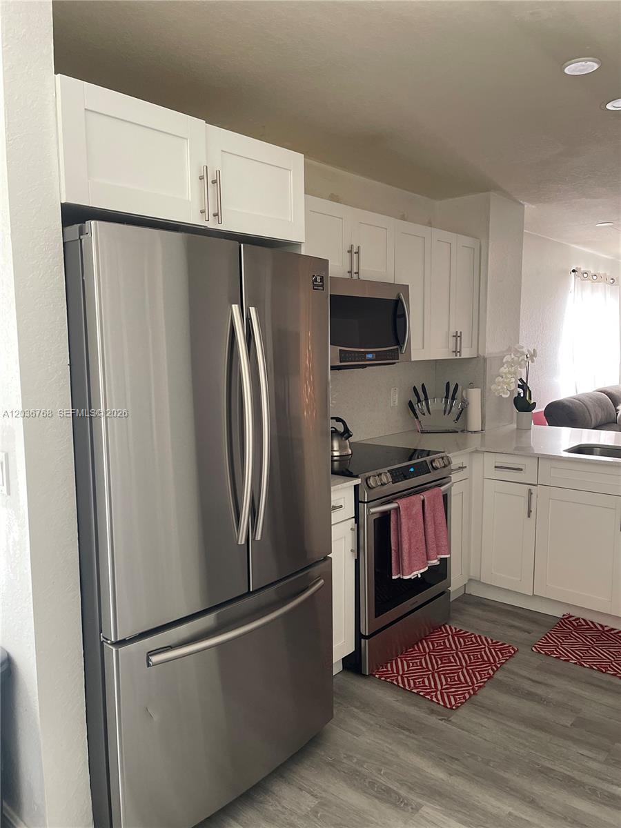 2432 Southwest 99th Way Miramar, FL 33025 - Photo 2 of 17 a kitchen with stainless steel appliances granite countertop a refrigerator stove and sink