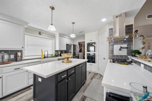 a kitchen with a sink a stove a refrigerator and cabinets