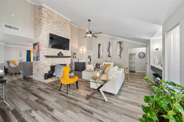 a living room with furniture a flat screen tv and a fireplace