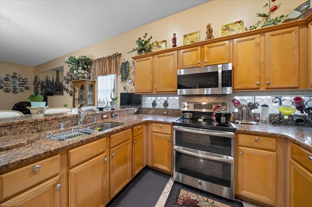 1010 Raining Meadows Lane Orlando, FL 32824 - Photo 16 of 57 a kitchen with a sink stove and microwave