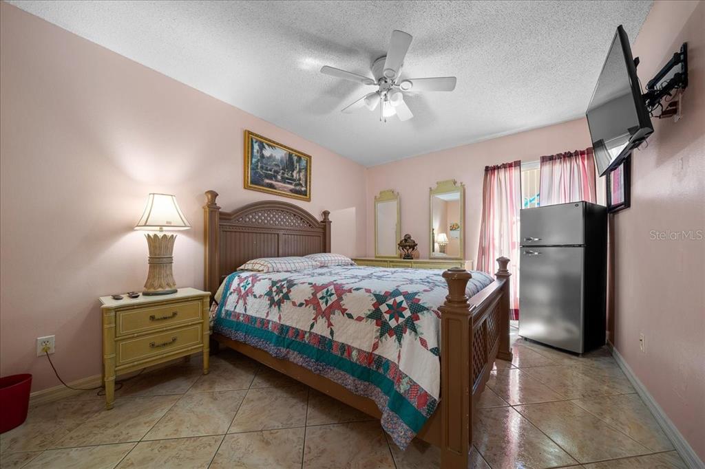 1010 Raining Meadows Lane Orlando, FL 32824 - Photo 35 of 57 a bedroom with a bed and a refrigerator