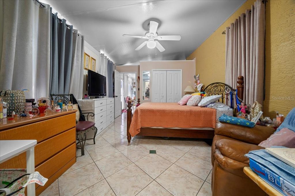 1010 Raining Meadows Lane Orlando, FL 32824 - Photo 43 of 57 a bedroom with a bed television and a large window