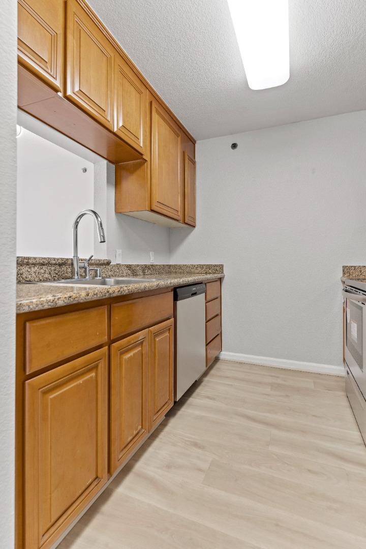 29581 Highgate Drive, Unit 219 Hayward, CA 94544 - Photo 8 of 24 a kitchen with granite countertop white cabinets and white appliances