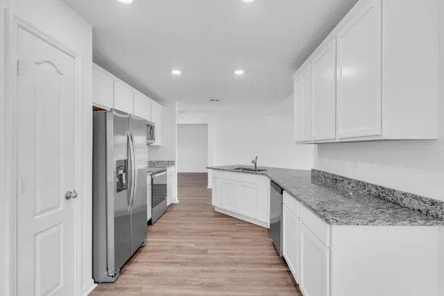 a kitchen with white cabinets sink and stainless steel appliances